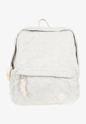 Mochila de tela gris claro con bolsillo frontal, tiradores de cremallera beige y asa superior, con un pequeño parche de logo cosido en la parte inferior del frontal.