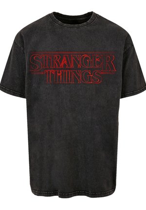 Schwarzes Baumwoll-T-Shirt mit dem "STRANGER THINGS"-Logo in kräftigem Rot. Kurze Ärmel, Rundhalsausschnitt, leicht abgenutzte Optik.
