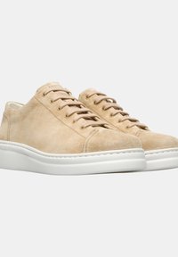 Beige nahka-tennarit valkoisella kumipohjalla, joissa on pyöreät nauhat ja minimalistinen muotoilu. Silkkinen pinta, jossa on sävyttämätön ompelu korostaa muotoa.