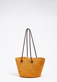 Woven yellow tote bag with a rounded shape, brown rope handles, and leather accents at the base of the handles. Textured surface.