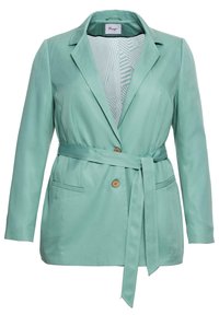 Blazer verde menta con colletto a revers, cintura a fusciacca, due tasche frontali e chiusura a pulsante in legno. L'interno presenta un motivo geometrico.