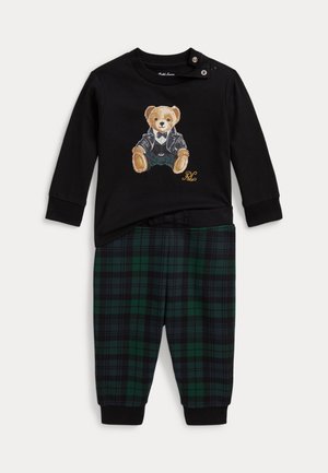 Tenue noire à manches longues pour tout-petit avec un imprimé d’ours en veste sur le haut et pantalon à carreaux verts et bleu marine avec des revers.