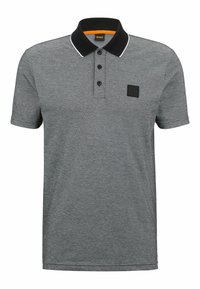 Grå polo skjorta med svart krage, tre knappar och ett litet logotypmärke. Den har ett texturerat tyg och vit akcent runt kragen.