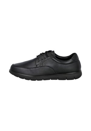 Zapato casual de hombre de piel negra con cordones, cuello acolchado y suela de goma flexible, vista lateral sobre fondo blanco.