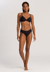 Schwarzes Bikini-Set mit einem gepolsterten, unterwired BH mit verstellbaren Trägern und einem moderat geschnittenen Hipster-Höschen. Glatte Stoffstruktur.