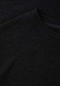 Nærbillede af sort strikket trøjestof, der viser ribbet rund halsudskæring og tekstureret maskemønster.