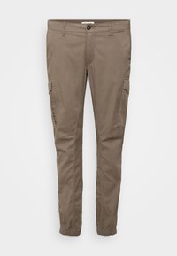 Cargo παντελόνια σε ανοιχτό καφέ χρώμα, κατασκευασμένα από βαμβάκι. Διαθέτουν πλαϊνές τσέπες, ελαστικές μανσέτες και κανονική ζώνη μέσης με κουμπί.