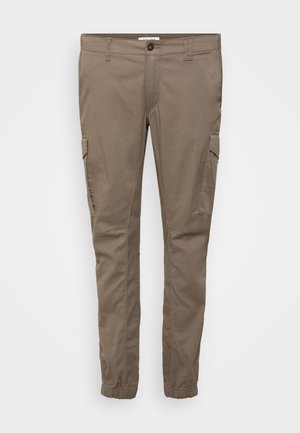 Spodnie cargo w jasnobrązowym kolorze, wykonane z bawełny. Posiadają boczne kieszenie, elastyczne mankiety oraz standardową talię na guzik.