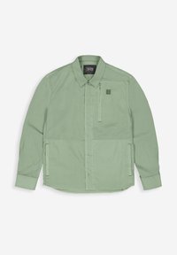Hellgrüne Hemdbluse mit einem Reißverschluss-Brusttasche, langen Ärmeln und einem strukturierten Stoff. Mit einem Logopatch auf der oberen linken Seite.