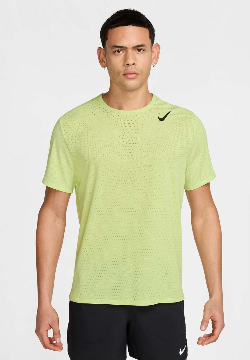 T-shirt de sport à manches courtes Nike en vert clair, avec un motif texturé et un logo noir contrastant sur la poitrine gauche.