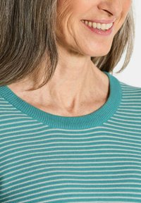 Türkis- und weißgestreifter Strickpullover mit rundem Ausschnitt und strukturiertem Stoff. Nahaufnahme des Kragenbereichs und eines Teils des Halses einer Person.