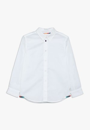 Vit långärmad skjorta med klassisk krage, som har rundad nederkant och färgglada detaljer vid sidsömmarna. Slät yta, tillverkad av bomull.