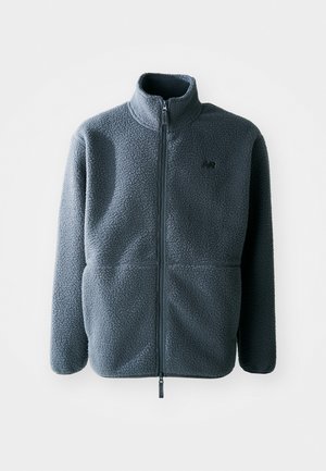 Gray fleece jacket with a high collar, front zipper, and two side pockets. Features a textured fabric and a small logo on the chest.
