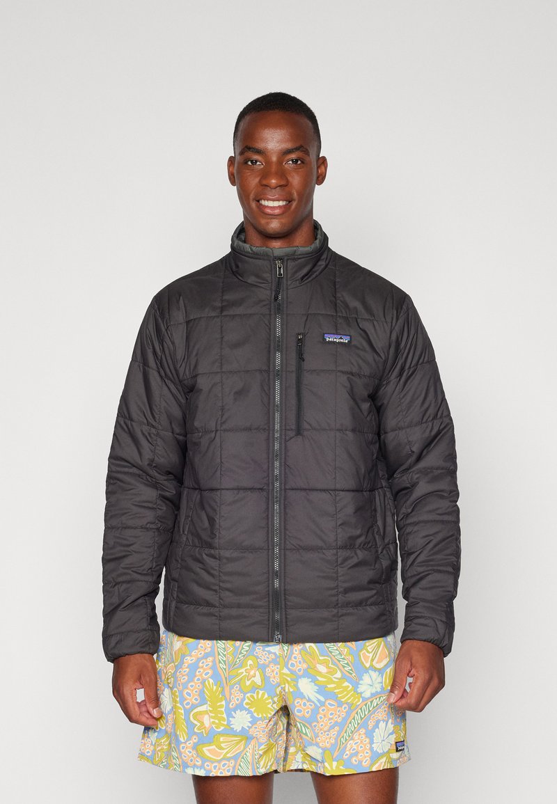 Veste doudoune noire isolée avec fermeture éclair sur le devant, col montant et motif cousu. Associe avec un short de bain floral multicolore.