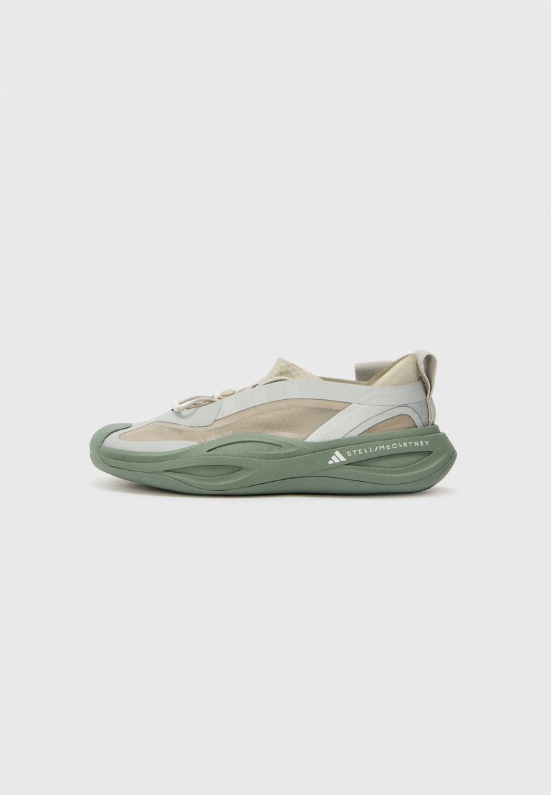 Sport shoes with a green rubber sole, light gray mesh upper, and beige accents. Features a streamlined design and elastic lacing system.