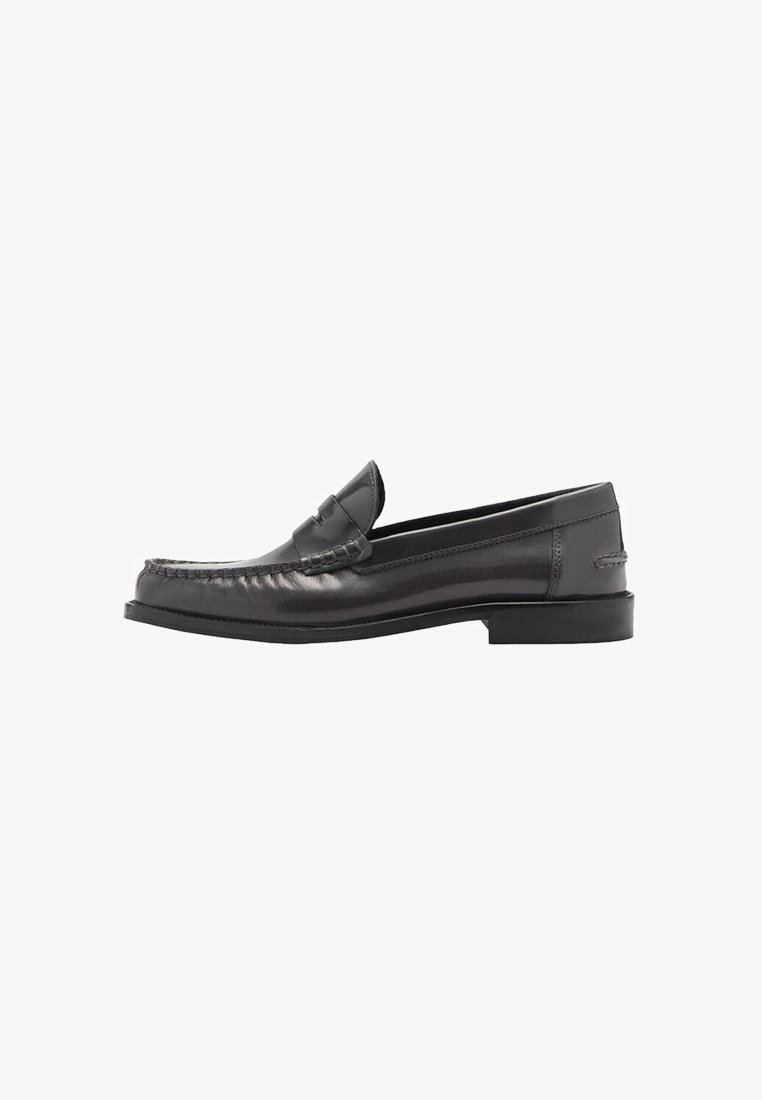 Mocassin en cuir noir avec petit talon, couture style mocassin et détail fente pour pièce sur le dessus, vu de côté.