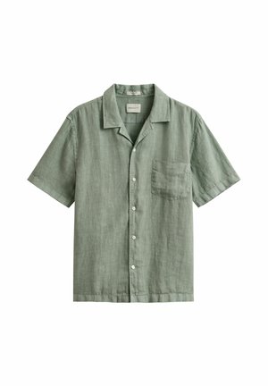Camisa de lino de manga corta en verde salvia con botones al frente, un bolsillo en el pecho y un cuello relajado, colocada sobre un fondo blanco.