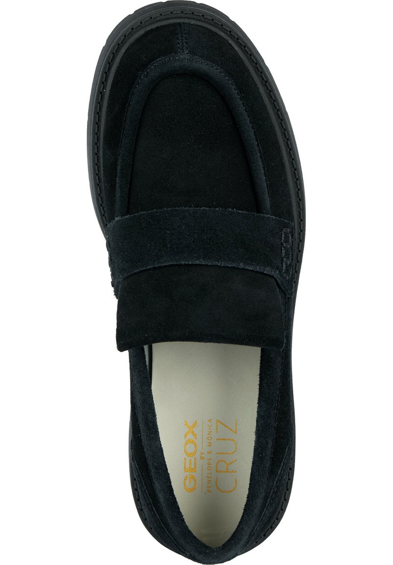 Scarpe slip-on in suede nero con una larga chiusura in velcro, punta arrotondata e soletta imbottita con branding dorato sul lato interno.