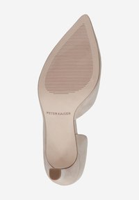 Zapato de tacón aguja beige con punta afilada y suela texturizada. Presenta un material superior suave y un detalle recortado en el talón.