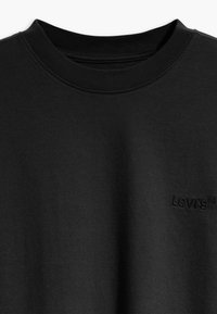 T-shirt en coton noir avec un col rond, présentant un petit logo "Levi's" en relief à l'avant. Texture lisse et design simple.