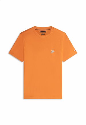 Oranges T-Shirt mit kurzen Ärmeln und Rundhalsausschnitt, mit kleinem weißen "TH"-Logo auf der linken Brust und kleinem Flaggen-Detail am linken Ärmel.