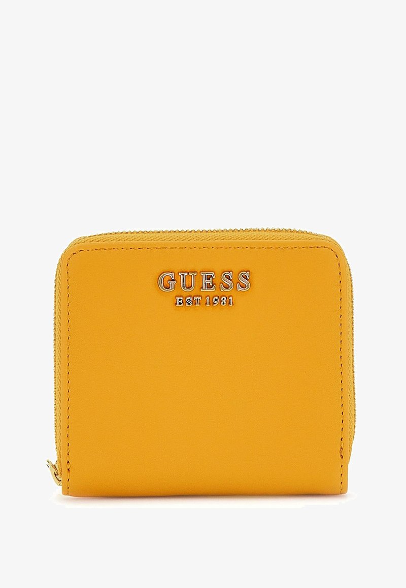 Kollane sünteetiline rahakott, millel on tõmblukuga sulgus, reljeefne "GUESS EST 1981" logo, sile tekstuur ja ristküliku kuju.