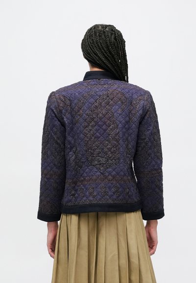 Μπουφάν με ραφές σε σκούρο μωβ και καφέ χρώμα με υφασμένο μοτίβο, διαθέτει μακριά μανίκια και μαύρη επένδυση στο τελείωμα των μανικιών και στο στρίφωμα.