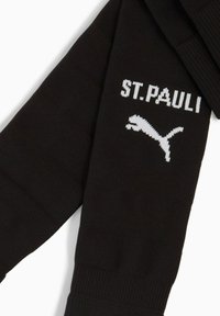 Czarne sportowe skarpetki z białym napisem "ST. PAULI" oraz logo Puma dzianym na przedniej części łydki.