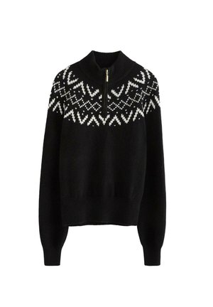 Sort strikket sweater med høj krave, der har en halv lynlås og hvide geometriske mønstre på brystet og skuldrene. Blød tekstur.