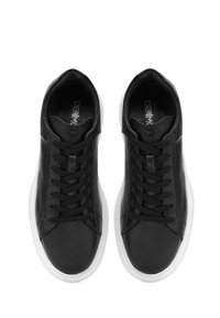 Sneaker in pelle nera con una texture liscia, dotata di suole in gomma bianca e lacci neri. Logo sulle sole interne, design della punta arrotondata.