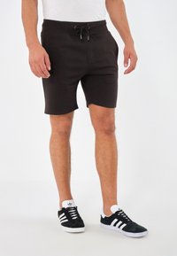 Shorts in felpa grigio scuro con vita elastica e cordoncino. Realizzati in tessuto misto cotone, presentano un design semplice e confortevole.