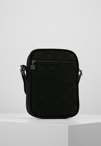 Borsa a tracolla nera realizzata in materiale testurizzato, con una tasca frontale con zip e un design a motivo, dotata di una tracolla regolabile colorata.