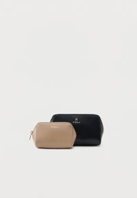 Two Furla pouches: one black, rectangular with pebbled texture; one beige, smaller, rounded with a smooth finish. Both have gold branding.