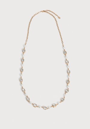 Collier doré orné de pierres rectangulaires transparentes et de perles blanches alternées, présenté sur un fond uni et clair.