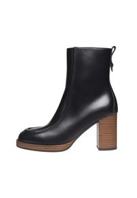 Black leather ankle boot with a smooth finish, rounded toe, and a chunky wooden heel featuring horizontal stripes. Back pull tab for easy wear.
