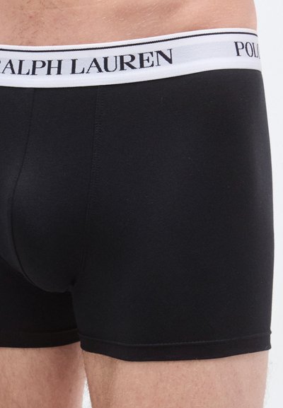 Cuecas boxer de algodão pretas com cinturilha elástica branca com o logótipo "RALPH LAUREN". Textura suave e design ajustado.
