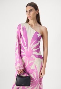 Kjole med én skulder i kremfarge med stort rosa blomstermønster; glatt stoff; lang arm med blonderdetalj. Svart håndveske med logo.