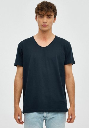 Camiseta de manga corta en azul marino con cuello en V, hecha de algodón suave. Cuenta con un corte holgado y una textura lisa, sin patrones ni acentos visibles.
