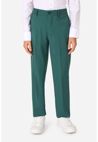 Pantaloni verde realizzati in tessuto testurizzato, con una singola piega frontale, tasche laterali e chiusura a bottone, abbinati a sneakers bianche.