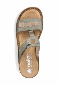 Grüne Wildledersandale mit geflochtenen beigen Akzenten, Korkfußbett, flacher Sohle und Metallringdetail. Rieker-Branding auf der Innensohle.