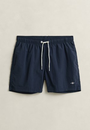 Donkerblauwe zwemshorts met elastische tailleband, witte trekkoord, zijzakken en een klein logo aan de linkerkant.