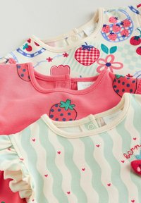 Tri otroške majice iz mehke bombažne tkanine: ena kremna z jagodnimi motivi, ena roza z velikimi jagodami in ena mint zelena z valovitimi črtami in srčki.