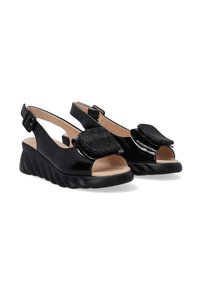 Zwarte gepatineerde leren slingback sandalen met open tenen, voorzien van getextureerde zwarte accenten en een golvende platformzool. Verstelbare gespband.