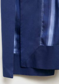 Cămașă albastră închisă cu o textură fină, având dungi verticale de culoare albastru deschis și un tiv curbat. Design curat cu accente de culoare contrastante.