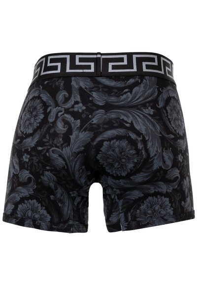 Shorts de boxe noirs avec des motifs floraux et de feuilles gris foncé. Présente une taille noire à motifs avec un design contrastant.