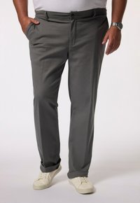 Graue, leichte Hose mit geradem Bein, seitlichen Taschen und Knopfverschluss, kombiniert mit weißen Sneakers.