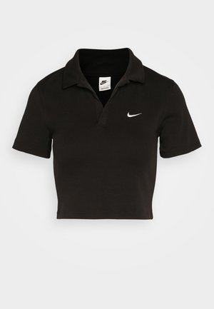 Black cropped polo shirt made of cotton with a traditional collar and short sleeves. Features a white Nike swoosh logo on the left chest.