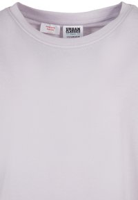 Svetlo vijolična organska bombažna majica z okrolim izrezom in etiketo znamke "Urban Classics", velikost 122/128 (ZDA 8) na notranji strani ovratnika.