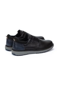 Scarpe in pelle nera con finitura liscia, punta arrotondata, design con lacci e suole in gomma grigia con accenti testurizzati sui lati.