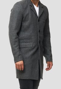 Manteau en mélange de laine gris avec une silhouette ajustée, col cranté, fermeture à boutons sur le devant et deux poches latérales. Tissu texturé avec un motif subtil.